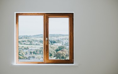 Wooden window frame set in a plain white wall