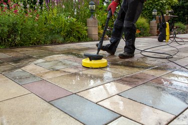 Cleaning stone slabs on patio.