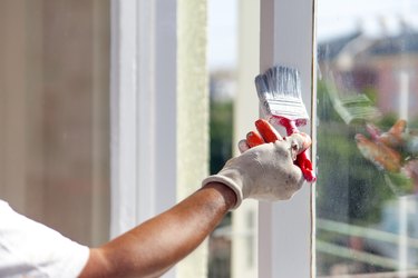 Man painting frame of the window