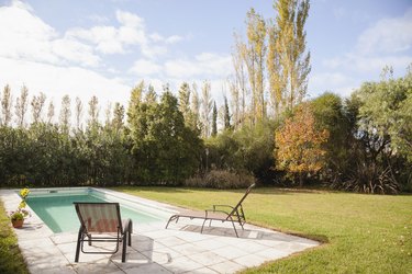 Deckchairs at poolside in garden