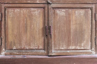 Old ancient grunge scratched dirty peeling paint vintage brown wooden cabinet texture abstract background