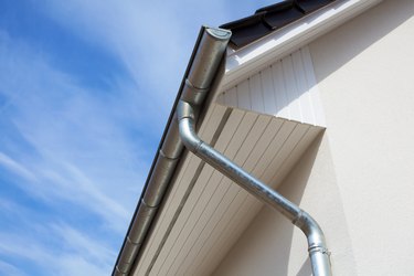 Architectural close-up of a metal rain gutter with downspout