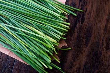 Fresh Chives / Siniklav or Frenk Sogani on wooden surface.