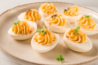 Boiled eggs stuffed with yolk with mayonnaise, on a white plate, selective focus, blurry, close-up, no people,