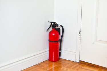 Fire Extinguisher Sitting Behind the Door at Home