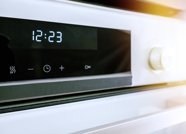 Control panel of a modern oven with the clock timer flashing.