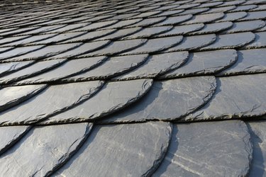 roofing: pattern of gray slate on an antique roof lightend by the sun, Germany