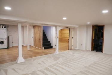 Renovated and completely finished basement with vinyl flooring, plush carpeting and a bedroom and bathroom