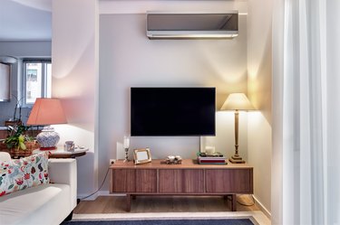 Wooden cabinet with flat tv and lamps on a small living room.