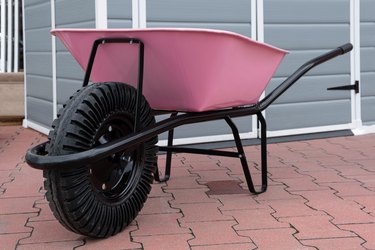 New pink garden wheelbarrow on patio.