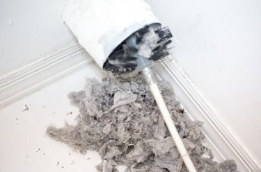 Lint being removed with a brush from a dryer vent