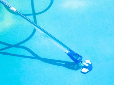 cleaning swimming pool by vacuum cleaner