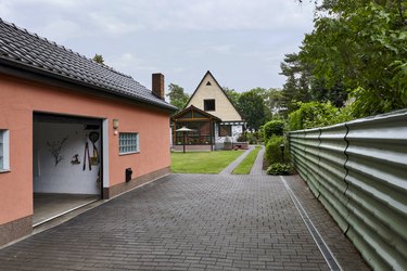 Open roller door of a garage in front of a paved yard