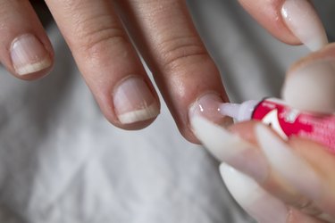 Artificial nail process at home. Applying glue to nails.