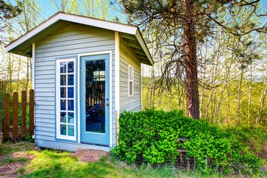 Small blue shed close-up. Forest landscape .