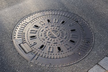 Iron cover of a manhole in a street.
