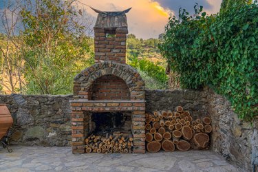 Fireplace on the backyard. Open summer barbecue kitchen with grill and wooden.