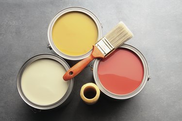 three paint cans with brush and roller