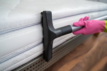 Vacuuming a mattress.