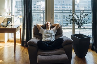 Young man relaxing on a reclining chair at home.