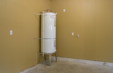 White water heater in corner of unfinished room