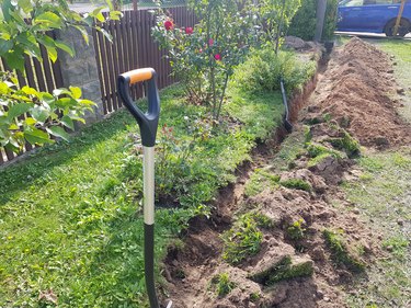 Shovel sticks out in ground on trench
