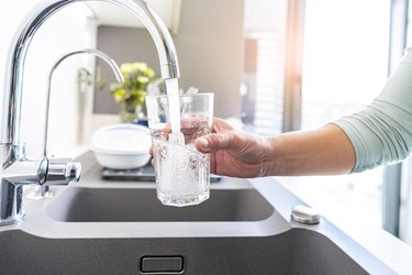 Filling glass of water from kitchen tap.