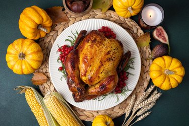 Roasted whole chicken or turkey with autumn vegetables for thanksgiving dinner on table. Thanksgiving Day concept. Celebrating Thanksgiving
