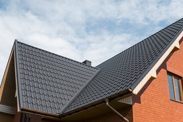 Modern roof covered with tile effect PVC coated brown metal roof sheets.