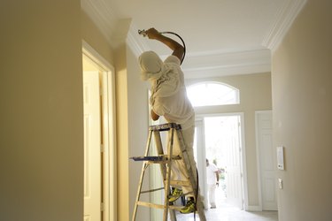 Series-Real painter spraying crown molding in a home