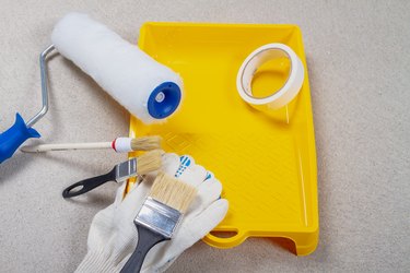 A set of tools for painting walls with paint. Brushes, tray, roller on the concrete floor