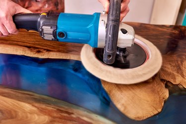 man polishing epoxy table close up