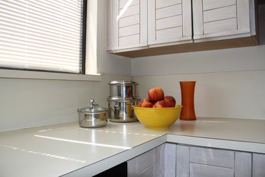 Kitchen counter with cookware and bowl of peaches