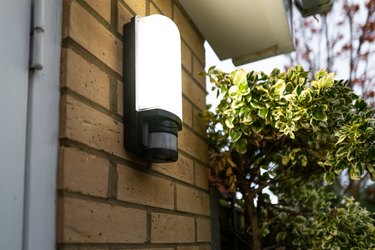 Exterior PIR LED security light seen glowing following body motion detection via its Infra Red sensor.