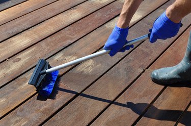 Cleaning Deck With Blue Gloves And Brush