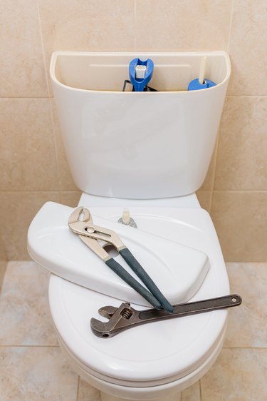 Plumbing tools in the toilet on a white toilet bowl