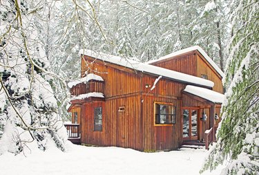 Modern wood cabin in snowy forest.