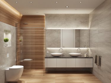 Modern contemporary bathroom with toilet, walk-in shower, two sinks, and large mirror.