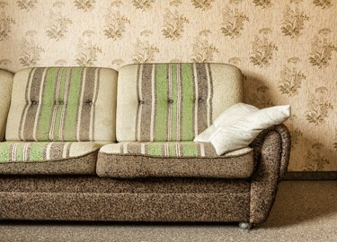 Old brown and green three-seat couch in a living room