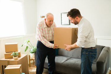 Elderly man moving into a new apartment with the help of his son