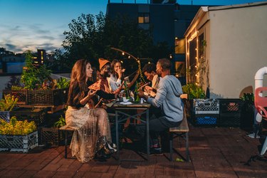 Dinner party with friends on a rooftop at night