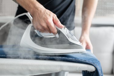 Steam ironing jeans.