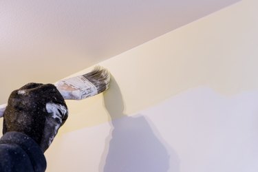 Close up of painter hands with painting the wall edge with brush