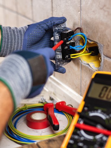 Electrician at work with safety equipment on a residential electrical system. Electricity.