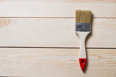 One Clean New Paint Brush, On A Wooden Background. Painting, Repair And Construction Work. Copy of the text Space. The concept of the construction industry, professional and home repair.