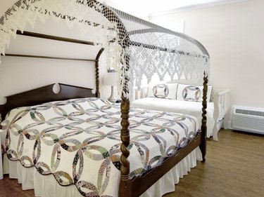 Canopy bed with antique quilt.