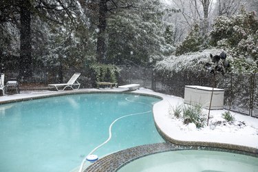 Backyard Winter Pool in Snow with Clear Blue Water and White Trees