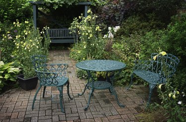 Painted wrought iron table and chairs in garden..