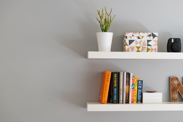 Modern Floating Bookshelves With Books, a Plant ,and Decorative Box