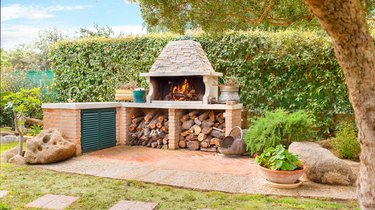 External Wood oven with burning fire and firewood